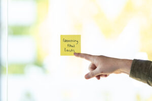 vinger wijzened naar een post-it op een glazen muur of raam op kantoor