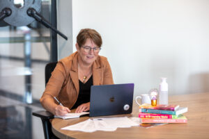 Portretfoto van coach irma aan het werk achter de laptop op kantoor